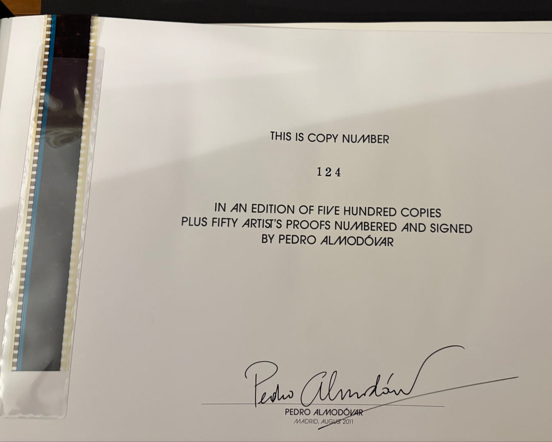 A white paper copy of a document or certificate with printed text and a signature, photographed inside a black folder or binder with a clear protective sleeve.